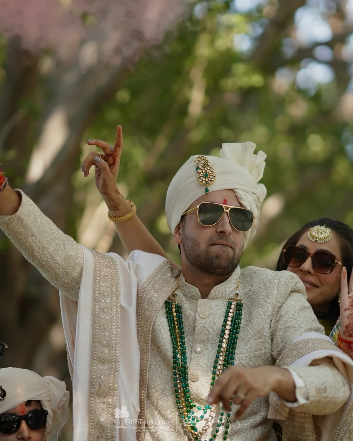 Groom in an ivory wedding safa with emerald jewellery for baraat pagri tying in Diani